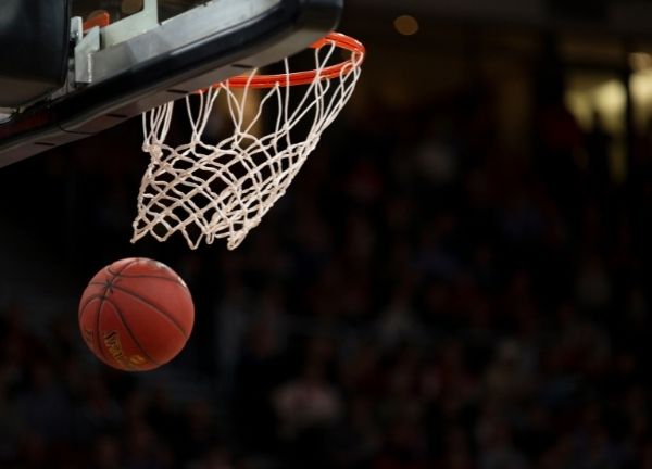 A basketball going through the net.